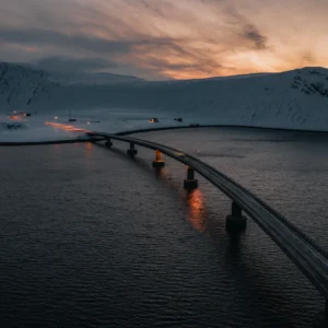 Pont moderne au coucher de soleil sur fjord enneigé scandinave