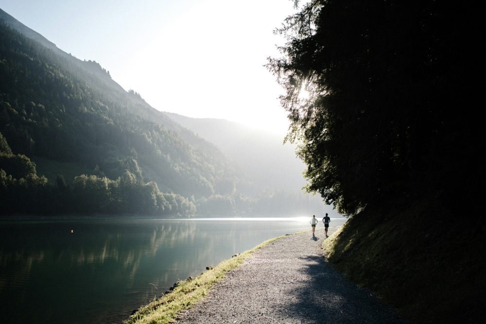 Paysage montagnard paisible avec lac et sentier forestier au coucher de soleil
