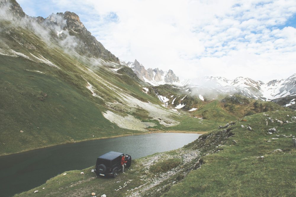 Vallée alpine avec lac et montagnes enneigées en toile de fond