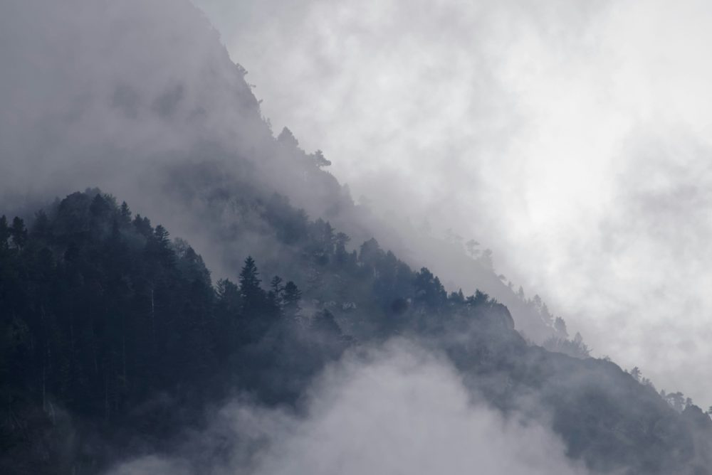 Papier Peint Montagnes Brumeuses dans les Nuages Atmosphère Mystérieuse